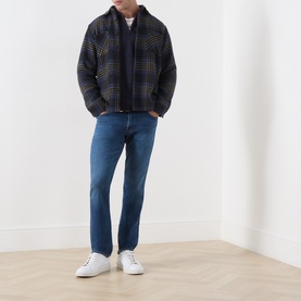Model wearing Citizens of Humanity Gage Slim Leg Jeans in Watson mid wash, styled with a plaid jacket and white trainers.