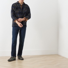 Model wearing Citizens of Humanity Indio straight jeans in dark indigo, styled with a navy check overshirt and grey trainers.