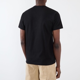 Model wearing Comme des Gar&ccedil;ons Play black cotton T-shirt, rear view, styled with beige trousers