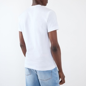 Model wearing Comme Des Gar&ccedil;ons Play Double Heart Embroidered Logo T-Shirt in white, rear view, styled with light blue jeans.