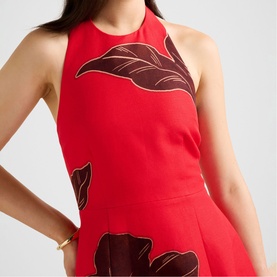 Model wearing Forever New red Dryden dress with halterneck and large floral print detail, styled with a gold bracelet.