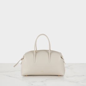 DeMellier The Stockholm Midi Top Handle Bag in Chalk grained leather, dual tubular handles, gold-tone hardware, zip fastening