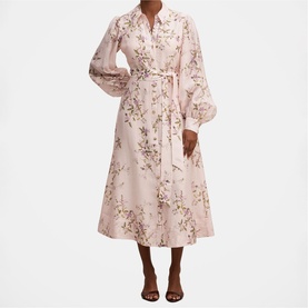 Model wearing pink floral midi shirt dress with billowy long sleeves, self-tie belt, and A-line skirt, styled with strappy heeled sandals