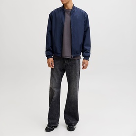 Model wearing navy blue bomber jacket with grey T-shirt and dark wash wide-leg jeans
