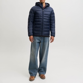 Model wearing Jack & Jones Kingsley Light Hooded Puffer Jacket in Navy Blazer, styled with light-wash wide-leg jeans and brown shoes.