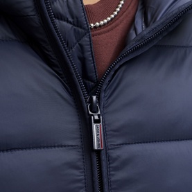 Model wearing Jack & Jones Kingsley Light Hooded Puffer Jacket in Navy Blazer, zip-up close-up detail with logo badge, styled with brown knit and