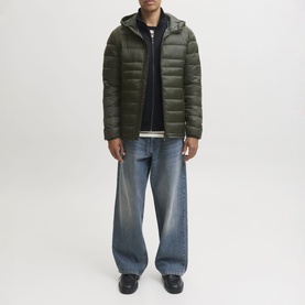 Model wearing Jack & Jones Kingsley Light Hooded Puffer Jacket in Rosin, styled with blue wide-leg jeans and black loafers.