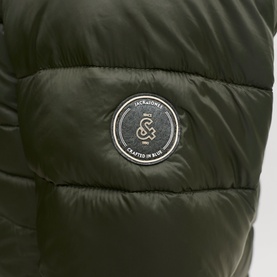Jack & Jones Kingsley Light Hooded Puffer Jacket in Rosin, close-up of circular logo badge on quilted nylon chest pocket.