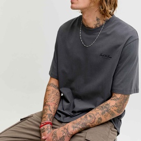 Model wearing Jack & Jones Archive Graphic Logo T-Shirt in Asphalt, crew neck with small chest logo print, styled with khaki trousers and silver