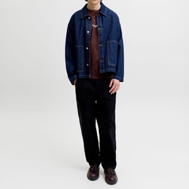 Model wearing indigo denim jacket with spread collar and chest pockets, styled with burgundy top and black trousers