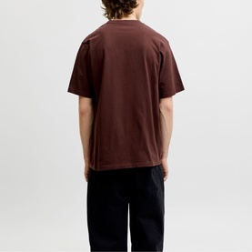 Model wearing dark brown oversized crew neck T-shirt, styled with black trousers, rear view