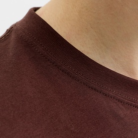Model wearing brown crew neck T-shirt, close-up of neckline stitching detail