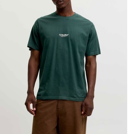 Model wearing Jack & Jones Soho Logo T-Shirt in Scarab, crew neck, short sleeves with small printed logo. Styled with tan trousers.