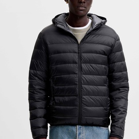 Model wearing Jack & Jones Berg Padded Hooded Puffer Jacket in black, zip fastening, styled with white tee and blue jeans