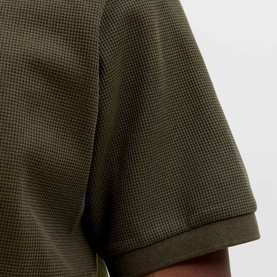 Model wearing Jack & Jones Austin Logo Polo Shirt in Rosin, close-up of textured stretch fabric and ribbed sleeve hem detail.