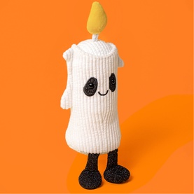 Jellycat Amuseables white candle plush soft toy with yellow flame, smiley face, and glittery black legs, on orange background