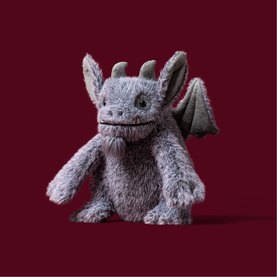 Jellycat grey fluffy dragon soft toy with wings, horns, and textured belly, shown on deep red background