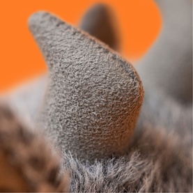 Jellycat grey plush soft toy close-up detail shot showing textured ear against orange background
