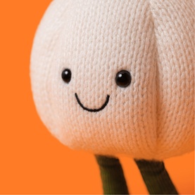 Jellycat Amuseeable white knitted tulip plush toy with smiley face and green stem legs, close-up detail shot