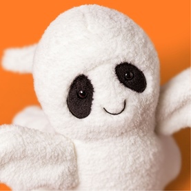 Jellycat white ghost soft toy with black eyes and a smile, shown close up against an orange background