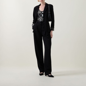 Model wearing Joseph Ribkoff black blazer with matching wide-leg trousers, monochrome printed top, and black flat shoes.