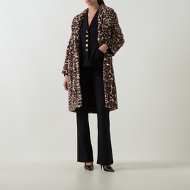 Model wearing Joseph Ribkoff Statement Button Blazer in black with leopard print faux fur coat, black flared trousers and black heels.