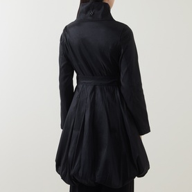 Model wearing Joseph Ribkoff black coat, rear view, showing belted waist, high collar, and voluminous pleated bubble hem.