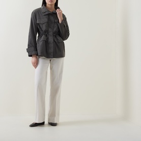 Model wearing Joseph Ribkoff Avocado nylon coat with drawstring waist, styled with white trousers and black flat shoes.
