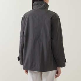 Model wearing Joseph Ribkoff Coat in Avocado, rear view, nylon fabric with stand collar and buckle cuffs, styled with white trousers