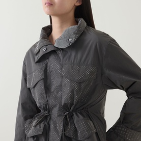 Model wearing Joseph Ribkoff Coat in Avocado, featuring perforated chest pockets, drawstring waist, and high collar detail.
