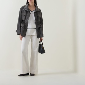Model wearing Joseph Ribkoff Avocado nylon coat with utility pockets and drawstring waist, styled with white knit and cream wide-leg trousers.
