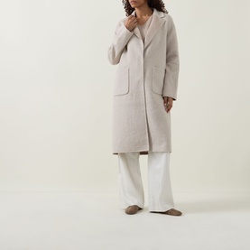 Model wearing Joseph Ribkoff Oatmeal Coat in relaxed longline silhouette with patch pockets, styled with white wide-leg trousers