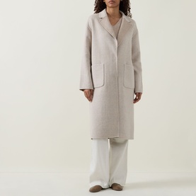 Model wearing Joseph Ribkoff oatmeal wool-blend longline coat with notch lapel and patch pockets, styled with white wide-leg trousers