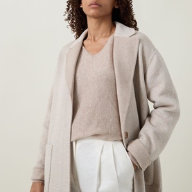 Model wearing Joseph Ribkoff Oatmeal coat with notch lapel, styled with a matching knit top and white trousers.