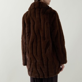 Model wearing Joseph Ribkoff Textured Faux Fur Coat in brown, shown from the back, highlighting textured wave-pattern faux fur and longline