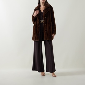 Model wearing Joseph Ribkoff Textured Faux Fur Coat in brown, single-breasted longline style, styled with wide-leg trousers and heeled sandals.