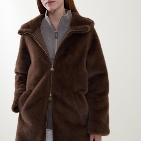 Model wearing Joseph Ribkoff Dark Mink faux fur coat with high collar and gold zip, styled over grey zip-up top.