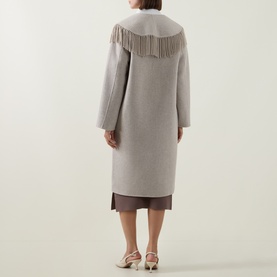 Model wearing Joseph Ribkoff Coat in Oatmeal, rear view, featuring fringe yoke detail, long sleeves, styled with brown midi skirt and cream heels.