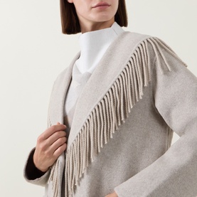 Model wearing Joseph Ribkoff Oatmeal coat with fringe trim detail, styled over a white top