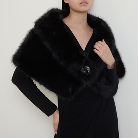 Model wearing Joseph Ribkoff Faux-Fur Collar Stole in black with V-shaped front and rhinestone brooch clasp, styled over a black dress.