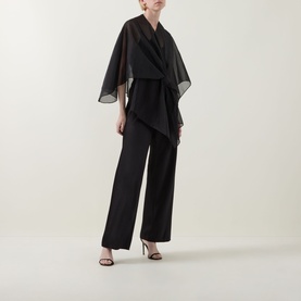 Model wearing Joseph Ribkoff Tie-Front Cover Up in black, semi-sheer shawl design with tie-front, styled with wide-leg trousers and heeled sandals.