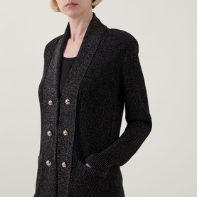 Model wearing Joseph Ribkoff Black/Gold sparkle knit cardigan with double-breasted gold buttons, paired with a black cami underneath.