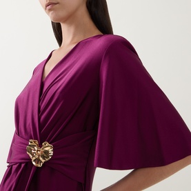 Model wearing Joseph Ribkoff Gathered Hardware-Detail Wrap Dress in Berry Burst with V-neckline, flutter sleeves and gold floral hardware detail.