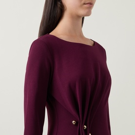 Model wearing Joseph Ribkoff Gathered Hardware-Detail Dress in Elderberry, showing wide round neckline, long sleeves and gold hardware gathered detail