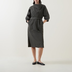 Model wearing Joseph Ribkoff Dress in Avocado, midi length with belted waist, high neck, puff sleeves and side pockets, styled with black flat shoes.
