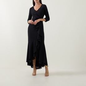 Model wearing Joseph Ribkoff Frill-Detail Layered Ruffle Dress in black, V-neck, three-quarter sleeves, high-low hem, styled with gold heeled sandals