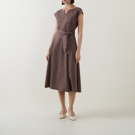 Model wearing Joseph Ribkoff Dress in Mink, featuring V-neckline, cap sleeves, tie waist, and A-line midi skirt, styled with cream heels