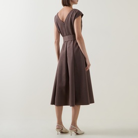 Model wearing Joseph Ribkoff Dress in Mink, showing V-back neckline, cap sleeves, belted waist and midi A-line skirt, styled with cream heels