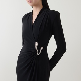 Model wearing Joseph Ribkoff black long-sleeve wrap dress with ruched waist and silver crystal hook brooch detail