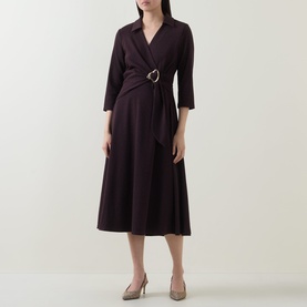 Model wearing dark purple wrap midi dress with three-quarter sleeves and D-ring belt, styled with nude heeled mules